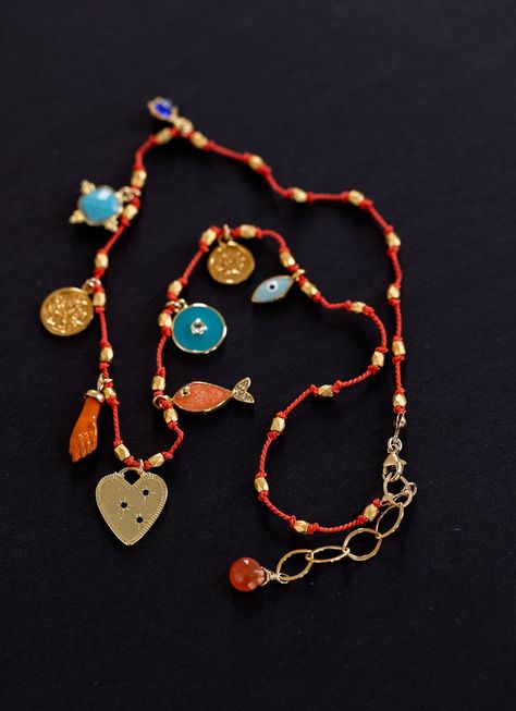 CHARM NECKLACE ON CORAL CORD DETAILS: *Charms: Nine gold plated charms. Heart, fish, tree of life, evil eye, lotus flower, turquoise pendant. *Cord: Hand knotted on coral color cord. *Clasp: Lobster. *Extension chain. *Select your size from the drop down menu. PROCESSING TIME: *4-6  business days.  All the jewelry on my site is made by me with love and care. ❤️ GIFT WRAP OPTION: *You can select gift wrap option. Your gift will arrive in a branded Alison Storry Jewelry pouch inside a    branded box. You can also request a message to be included on a small card. SPECIAL OFFERS: You can sign up to my news letter to hear about upcoming sales, new offers and new collections. http://www.eepurl.com/uHhYL FOLLOW ME AT: www.instagram.com/alisonstorry Colorful Evil Eye Jewelry, Enamel Charm Necklace, Heart Eye Necklace, Cord Pendant Necklace, Gold Beaded Jewelry, Gold Layered Jewelry, Coral Choker, Heart Fish, Flower Turquoise