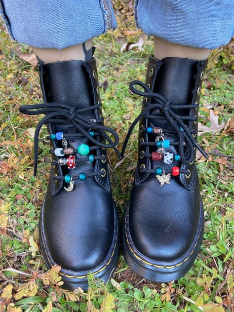 Black doc marten boots with different colored glass beads on the laces Diy Doc Martens Charms, Decorating Doc Martens, Doc Martens Beads On Laces, Upcycled Doc Martens, Doc Martens Beads, Beaded Doc Martens, Dr Martens Accessories, Shoe Charms Doc Martens, Doc Marten Accessories