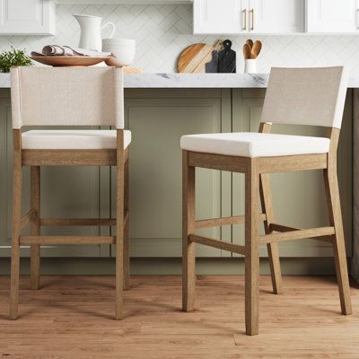 This solid wood modern bar stool has got your back (literally) covered. The bar stool has a thick, durable cushion upholstered in a charming material. The stool is crafted with sturdy rubberwood legs and holds up to 300 pounds, plenty for holding you and that extra glass of wine after work. It has a built-in footrest so you can enjoy each snack in complete comfort. This timeless counter stool will seamlessly blend in with your modern farmhouse home. Color: Natural Flax/Brown, Pack Size: 2, Seat Modern Farmhouse Barstools In Kitchen, High Stool Design, Modern Organic Bar Stools, Countertop Bar Stools, Kitchen Barstools Counter Stools, Leather Counter Stools With Backs, Barstools In Kitchen, Kitchen Island Stools With Backs, Kitchen Island Chairs