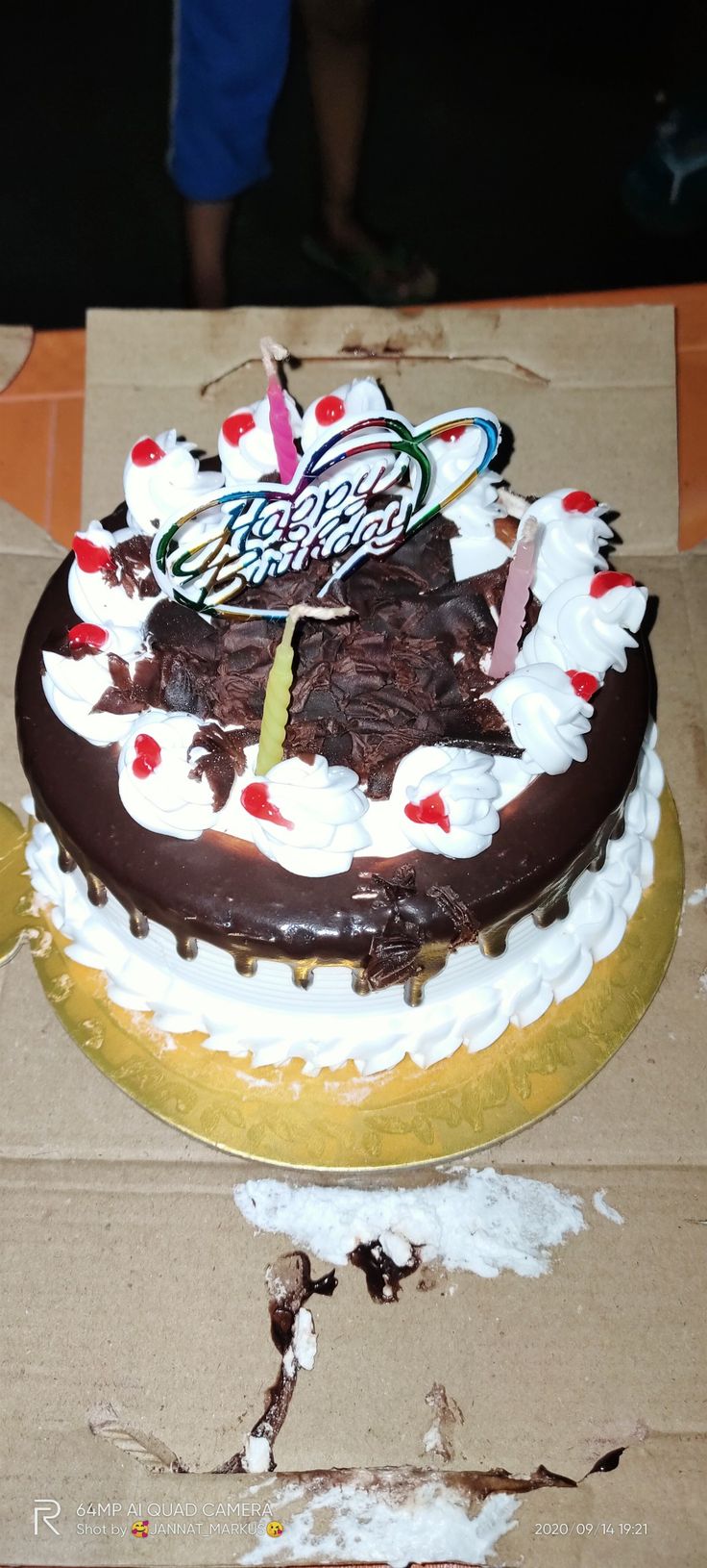 a birthday cake sitting on top of a cardboard box