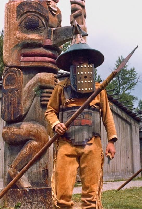 a man standing next to a wooden statue