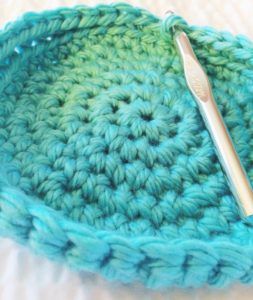 a crocheted dishcloth with a spoon in it