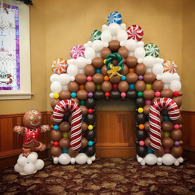 an arch made out of balloons and candy canes in the shape of gingerbread houses