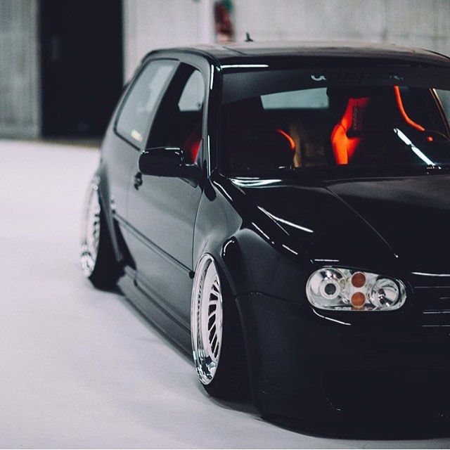 the front end of a black car parked in a garage