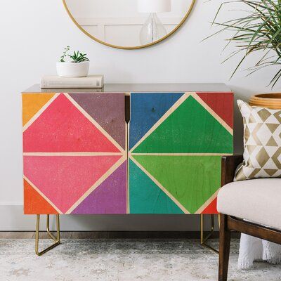 a brightly colored cabinet in the corner of a room with a mirror on the wall