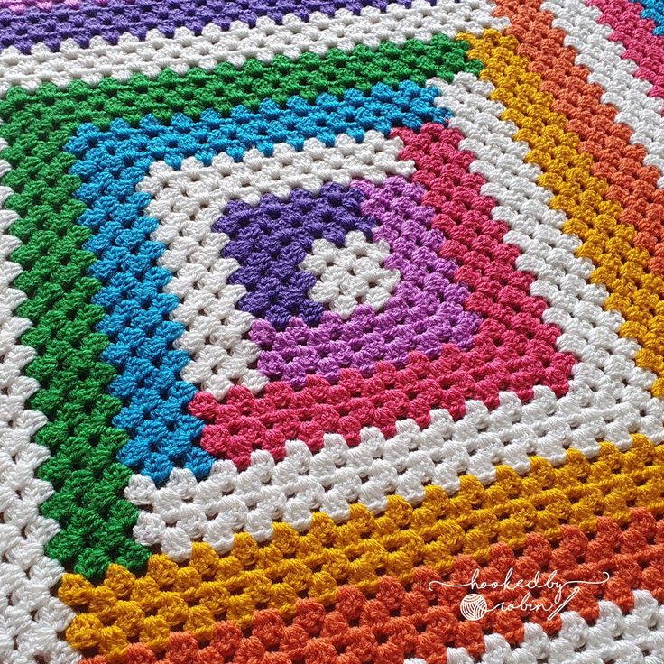a crocheted blanket with multicolored squares on it