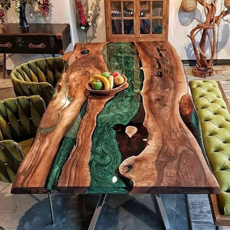 the table is made out of wood and has green velvet chairs