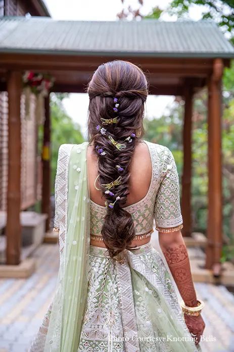 a woman with long hair wearing a green lehenga