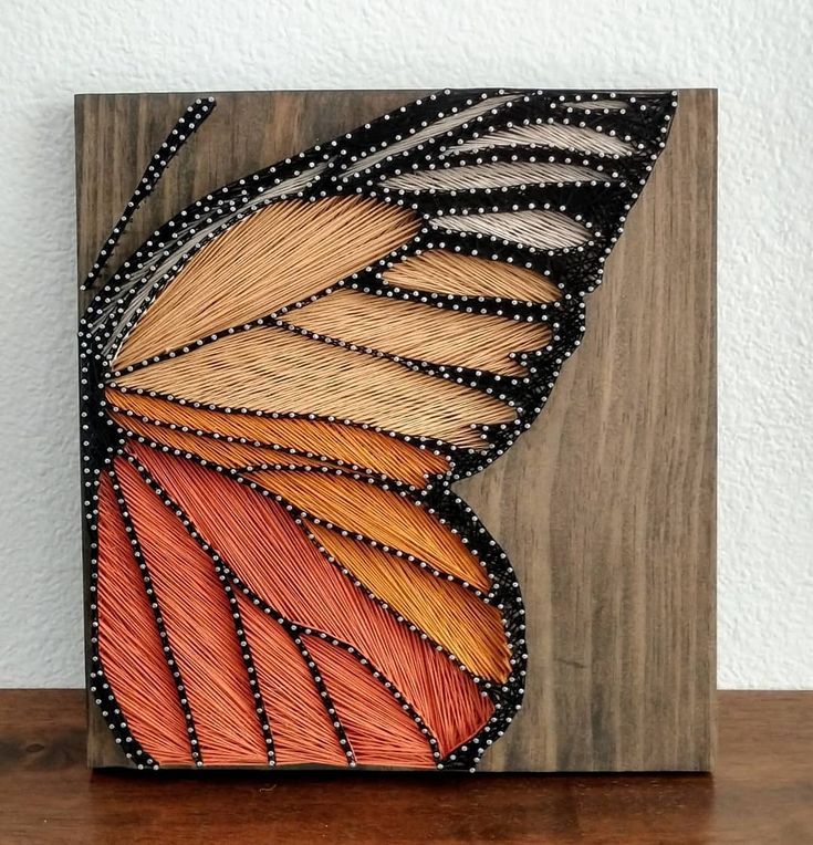 an orange and yellow butterfly wing painted on wood