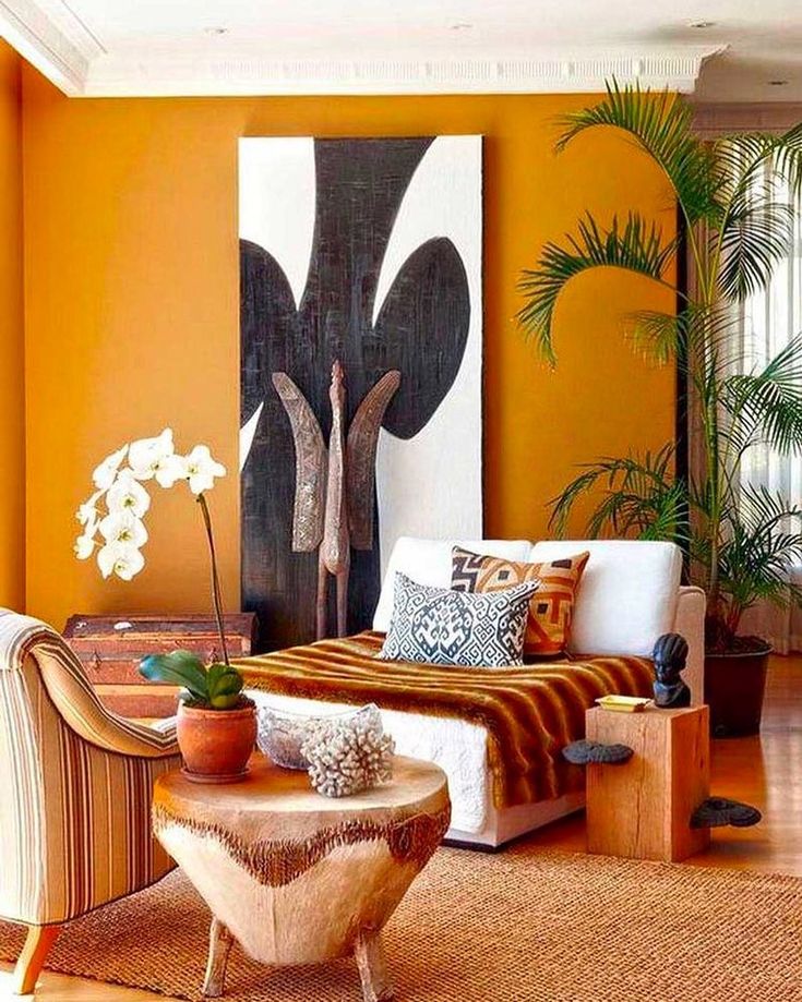 a living room with an orange wall and white furniture in the center, along with potted plants