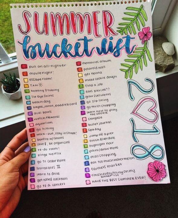 someone holding up a summer bucket list