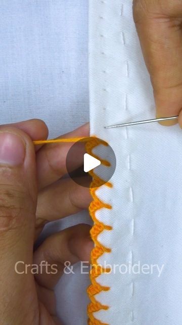 someone is stitching an orange piece of fabric