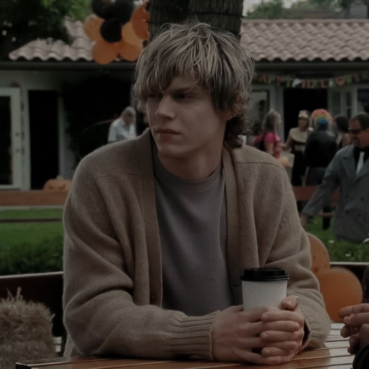 a man sitting at a table holding a coffee cup