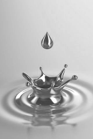 a water drop falling into a gold colored liquid with the reflection of a crown on it