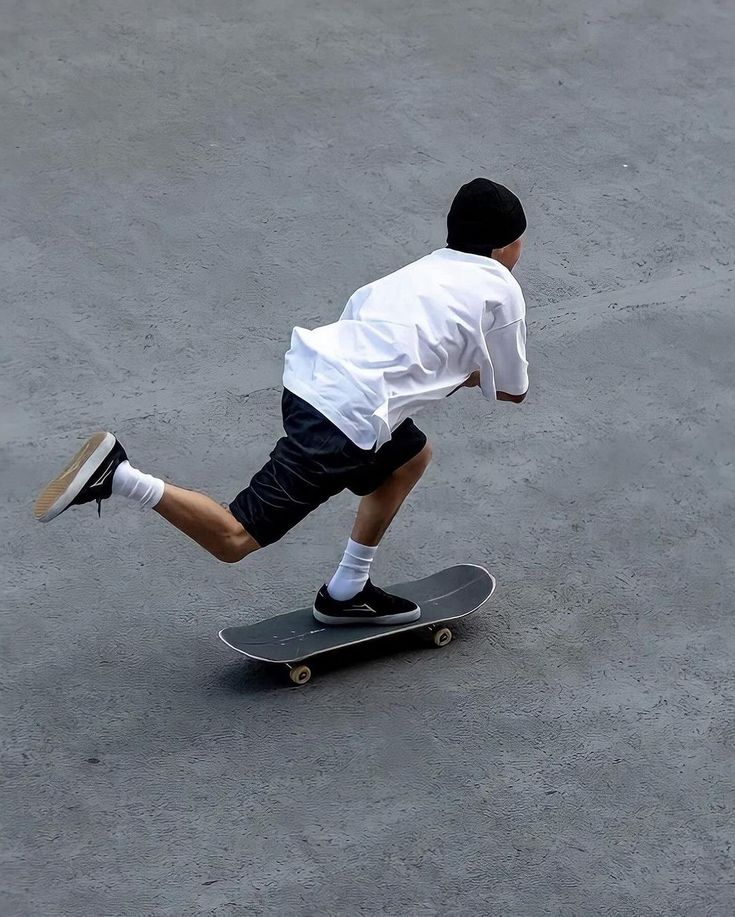 a young man riding a skateboard on top of cement