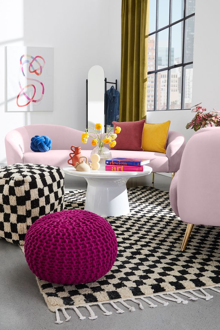 a living room filled with lots of furniture and colorful accessories on top of a black and white checkered rug