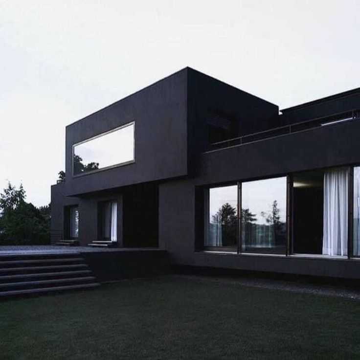 a black house with large windows and steps leading up to it