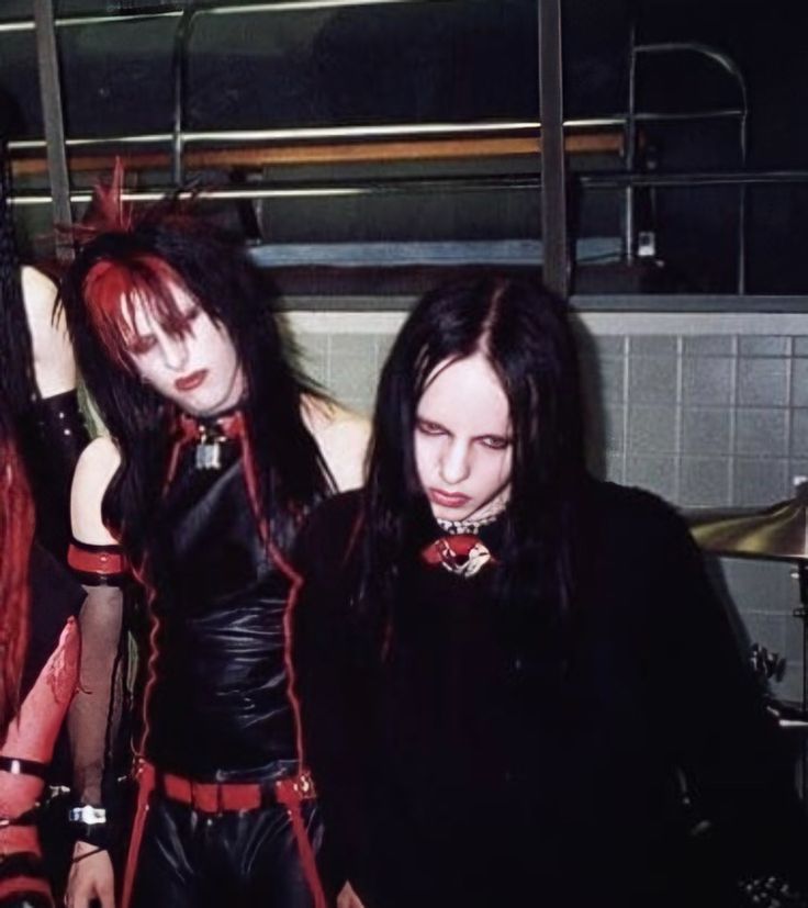 three women dressed in black and red posing for the camera