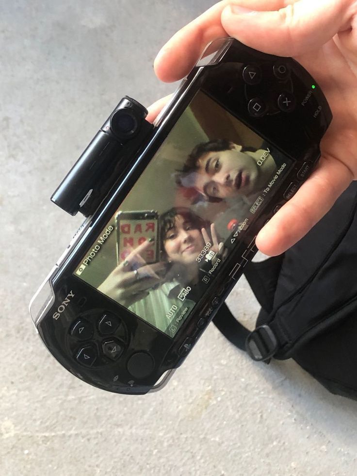 a person holding up a cell phone to take a picture with their child on the screen