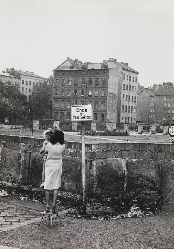 a woman standing on top of a brick road next to a sign that reads end