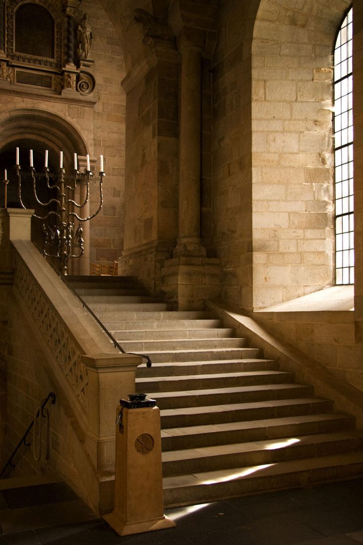 an old building with stone stairs and chandelier