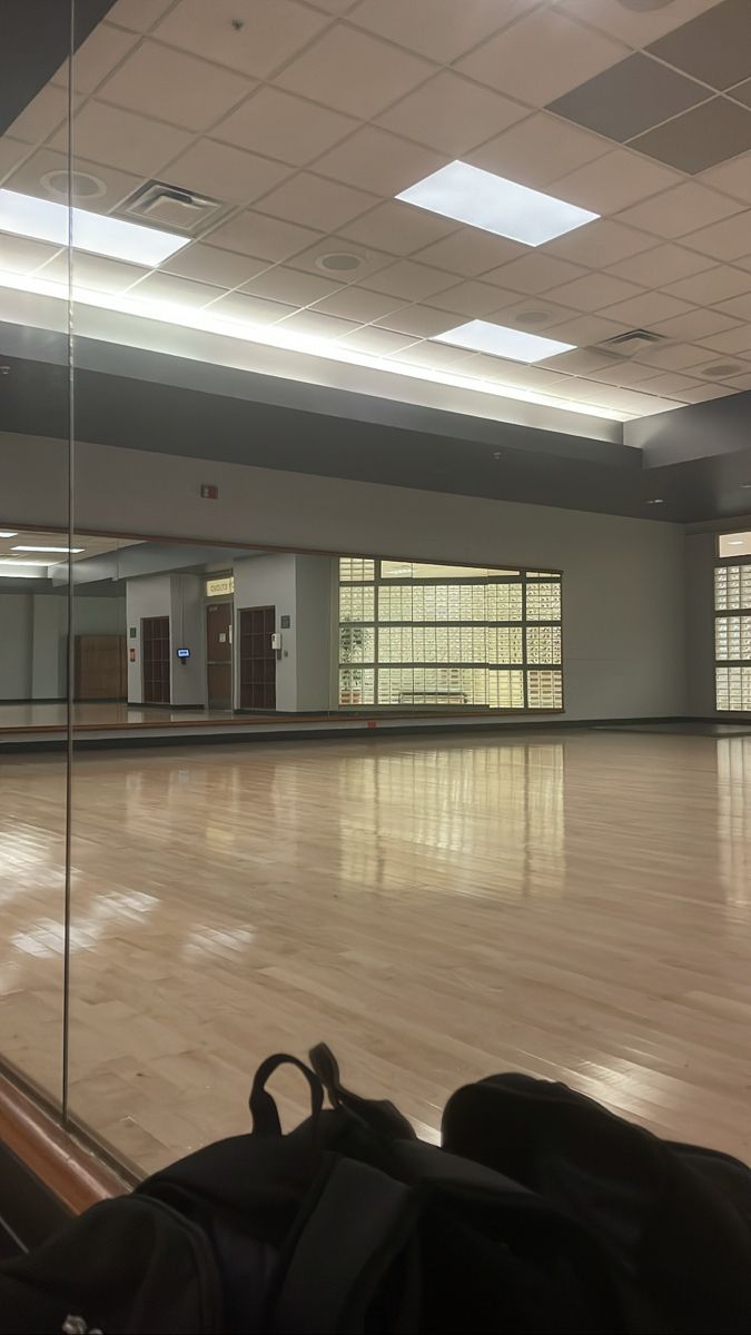 an empty room with hard wood floors and large windows