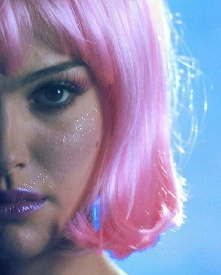 a woman with pink hair and glitter on her face is looking at the camera poster