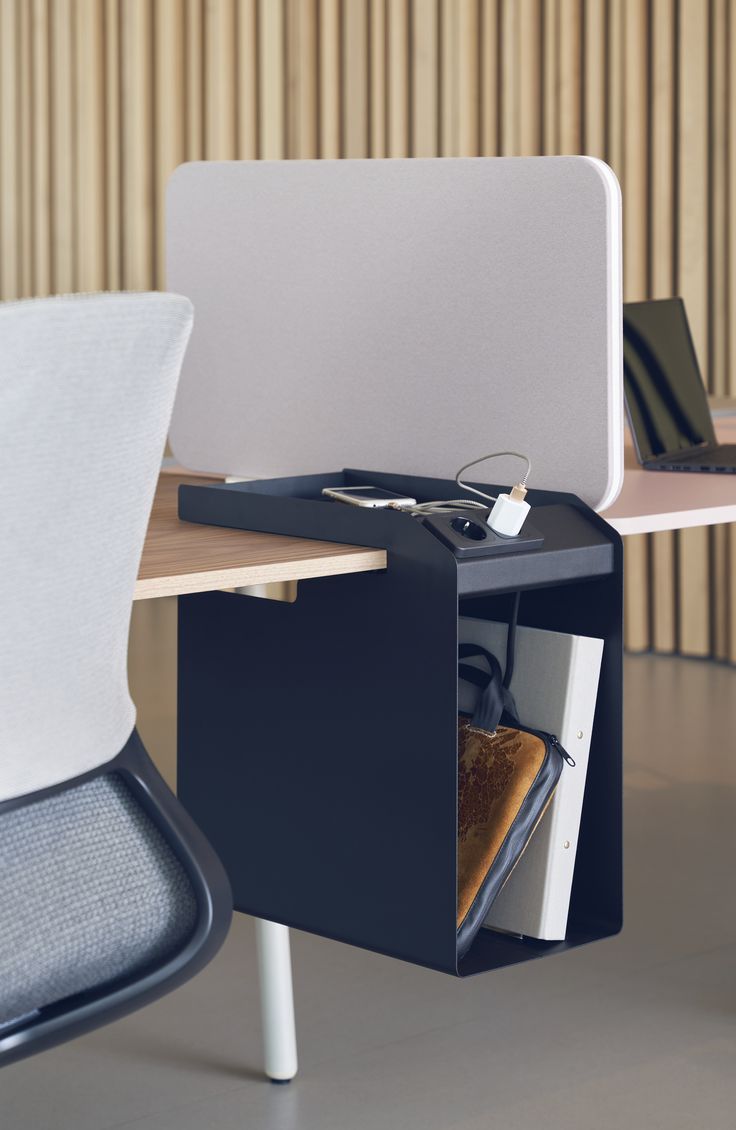 an open laptop computer sitting on top of a wooden desk next to a white chair