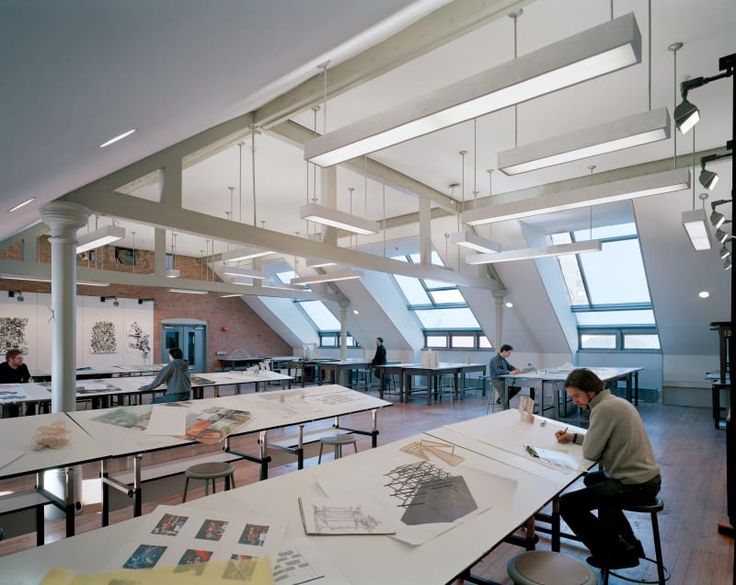 a man sitting at a table in an open room with lots of papers on it