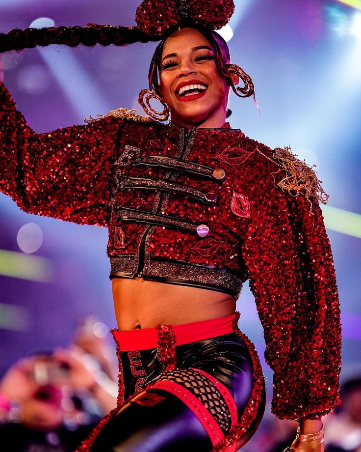 a woman in a red and black outfit on stage