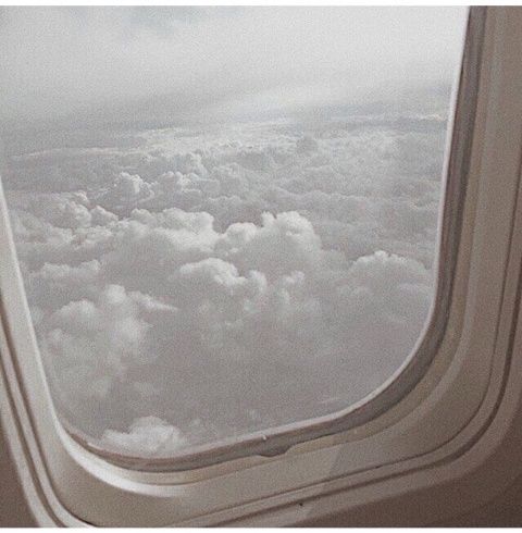 an airplane window looking out at the clouds