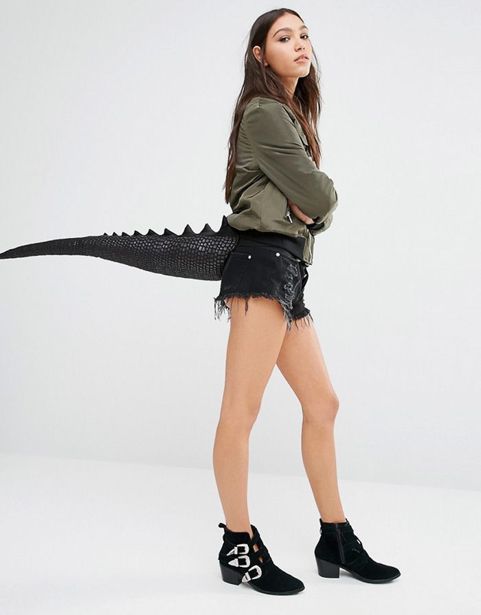 a young woman is posing with an alligator costume and high heeled boots on her feet