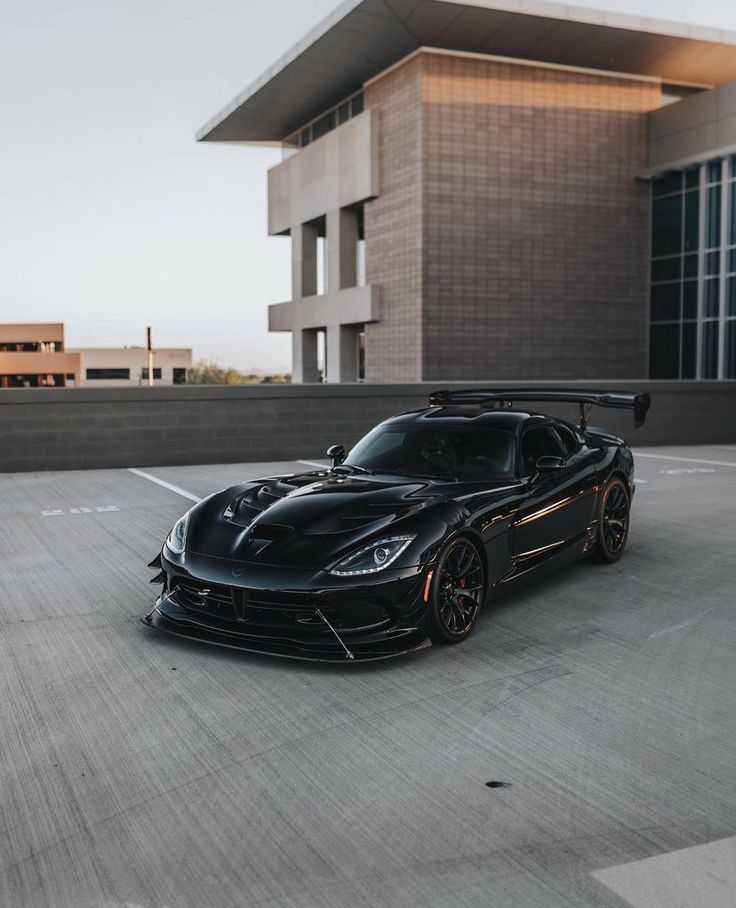 a black sports car parked in front of a building