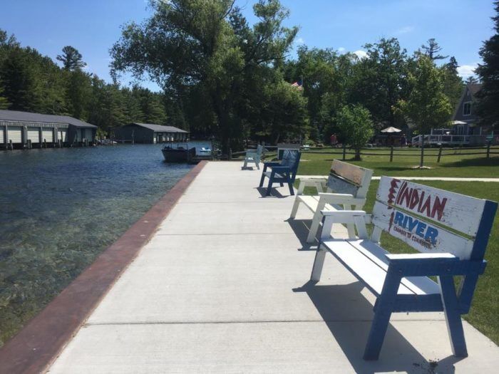 several benches are lined up along the water's edge, with a sign that reads finnnan river