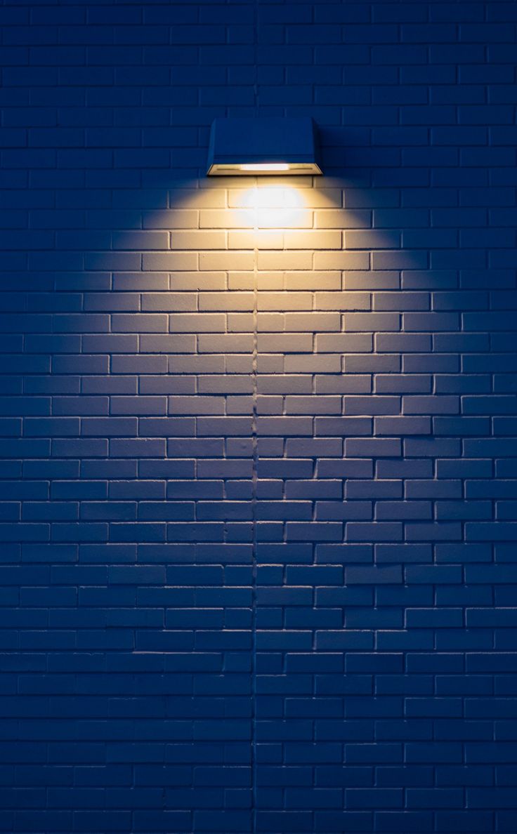 a blue brick wall with a light on it