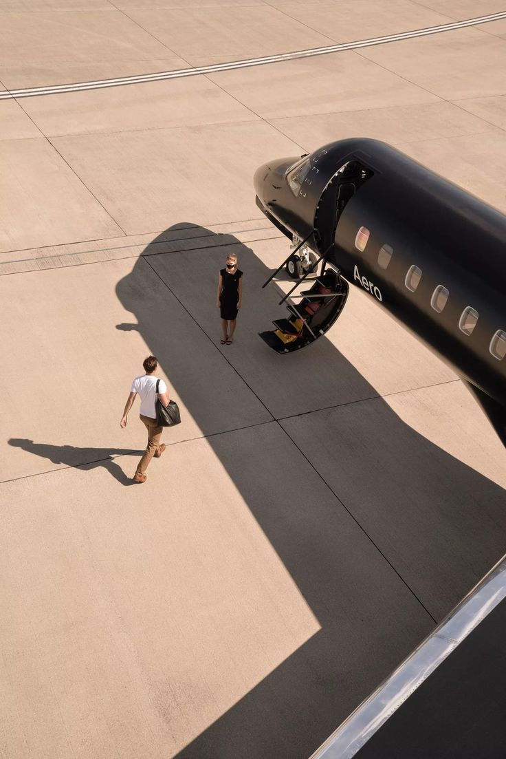 two people walking towards an airplane on the tarmac