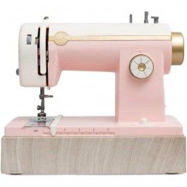 a pink sewing machine sitting on top of a wooden block