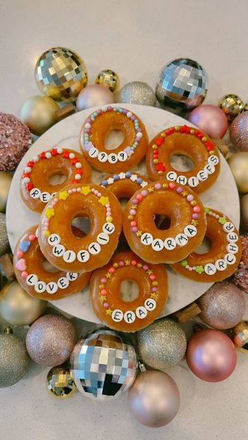 a white plate topped with donuts covered in frosting next to christmas ornaments and baubles