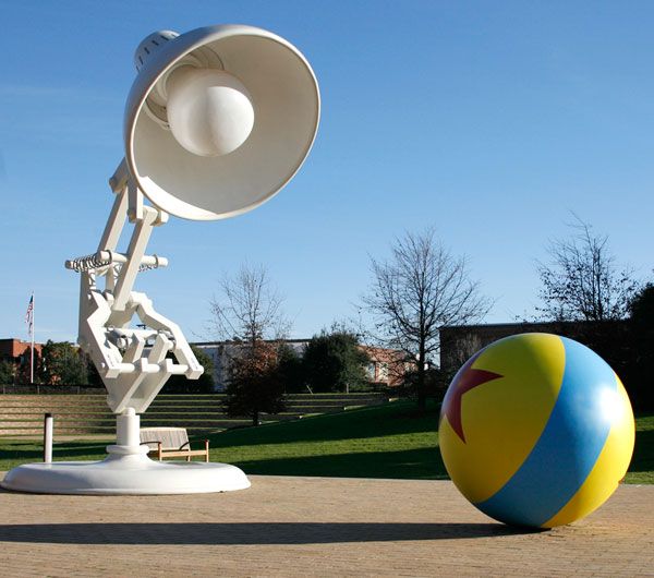 a large ball sitting next to a satellite dish on top of a cement ground