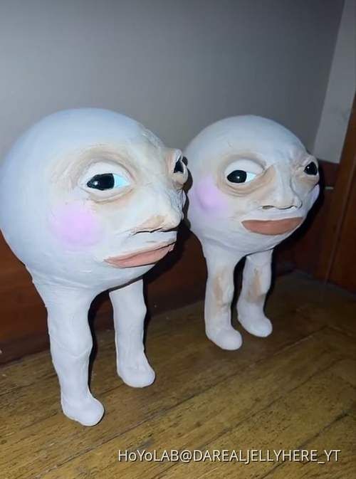 two white plastic animals standing next to each other on a wooden floor