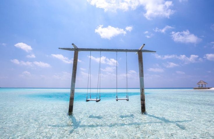 two swings in the middle of clear blue water