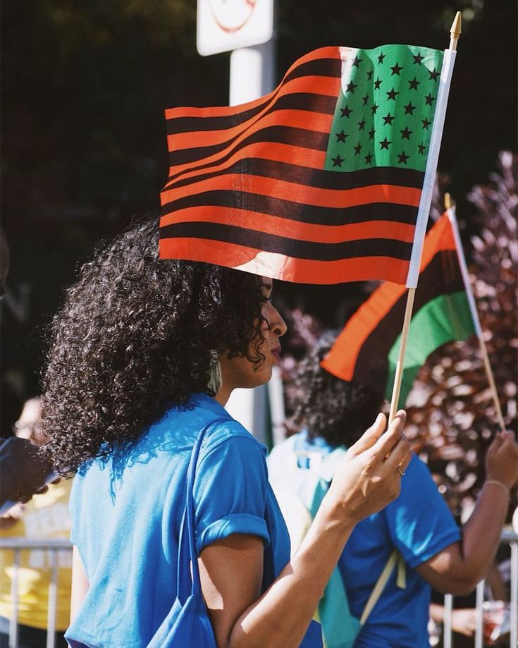 a woman holding an american and mexican flag