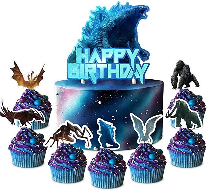 a birthday cake with cupcakes decorated like godzillas and monsters on it, surrounded by cut outs that say happy birthday
