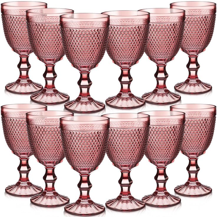 six pink glass goblets sitting next to each other