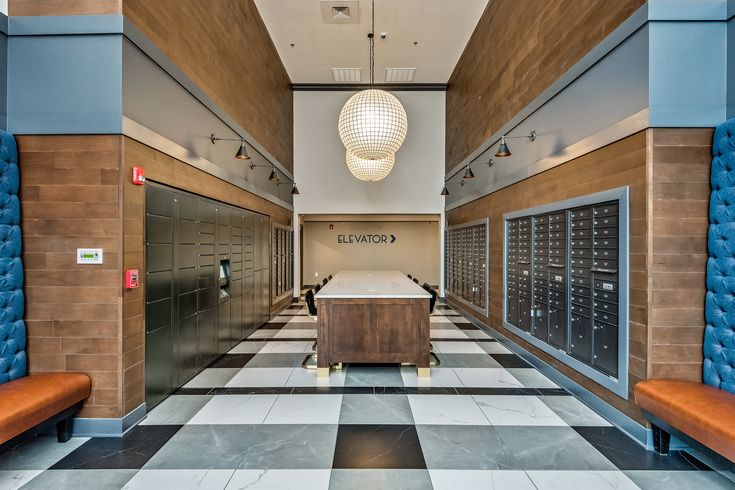 an office lobby with several mailboxes on the wall and two benches at the end