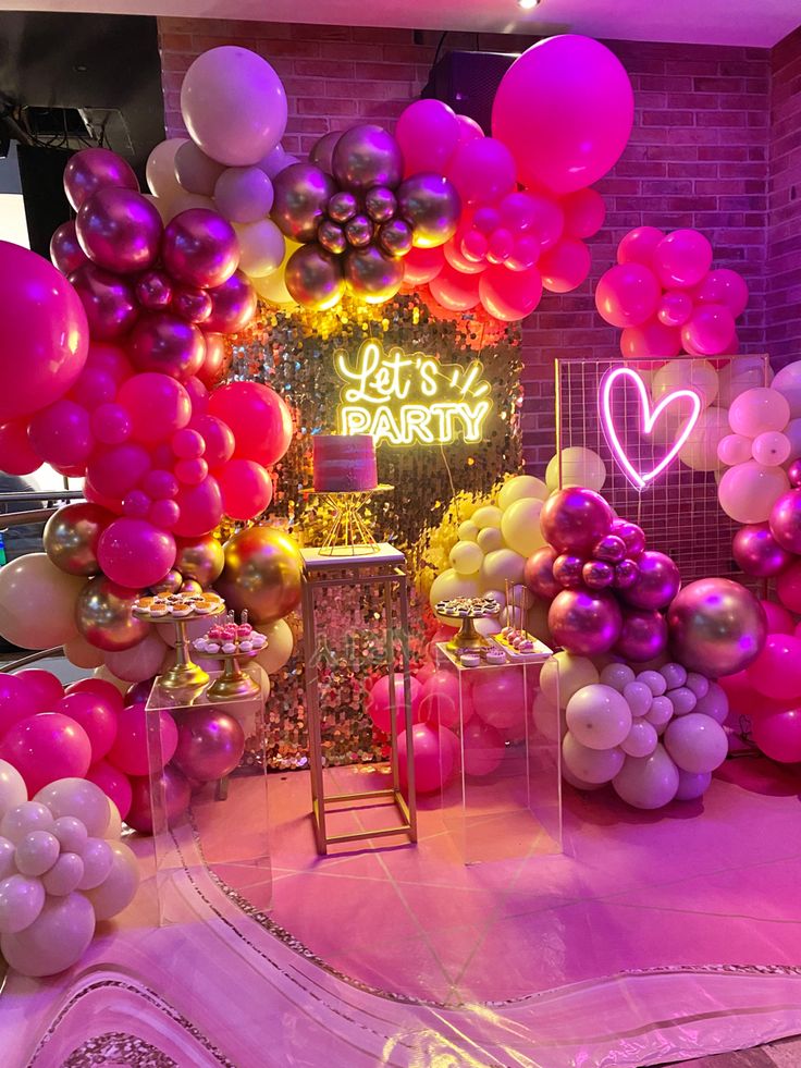 balloons and streamers are on display in a room decorated with pink, yellow, and purple colors