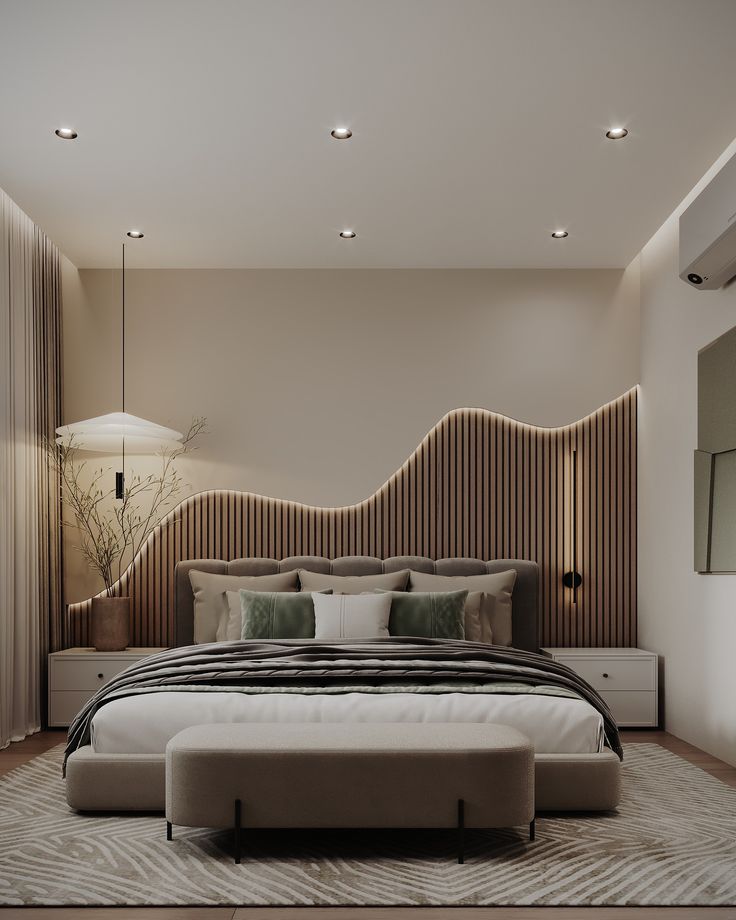 a large bed sitting in the middle of a bedroom next to a wall mounted lamp