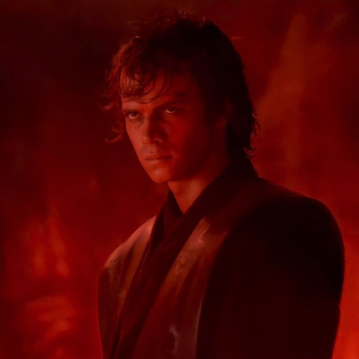 the young man is dressed in a suit and tie, staring at the camera with red light behind him