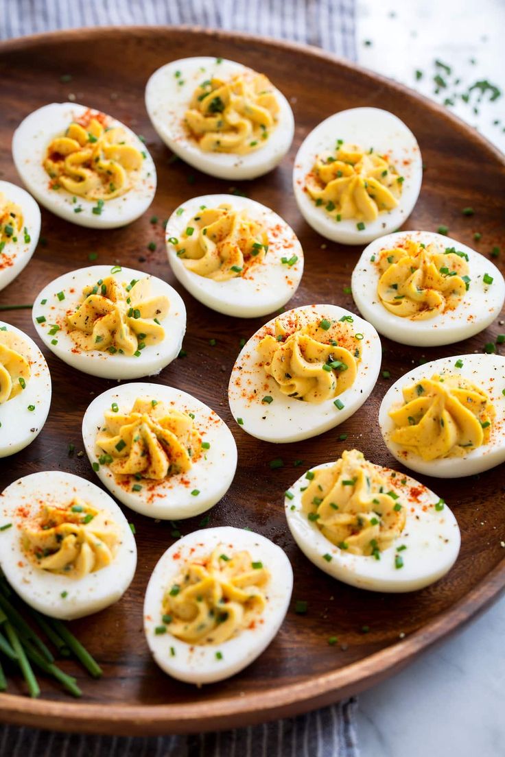 deviled eggs are arranged on a wooden plate