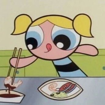 a cartoon character sitting at a table with chopsticks in front of her face